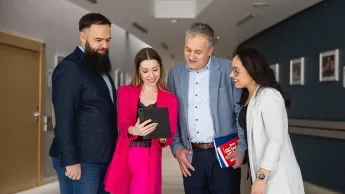 Coaching w standardzie ICF | Studia podyplomowe w Opolu | Uniwersytet WSB Merito Opole: Główna grafika: Opole- studia podyplomowe - Coaching w standardzie ICF - uczestnicy studiów podyplomowych analizują treści z tableta