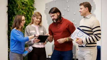 Zastosowanie AI w biznesie dla menedżerów | Studia podyplomowe w Opolu | Uniwersytet WSB Merito Opole: Główna grafika: Opole - studia podyplomowe - Zastosowanie AI w biznesie dla menedżerów - uczestnicy studiów podyplomowych rozmawiają i analizują wspólnie w czwórkę treści z tableta