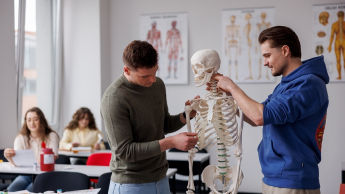 Dietetyka sportowa | Uniwersytet WSB Merito Opole: Główna grafika: Opole  studia II stopnia z podyplomowymi- Dietetyka sportowa - uczestnicy analizują szkielet człowieka w laboratorium dietetycznym