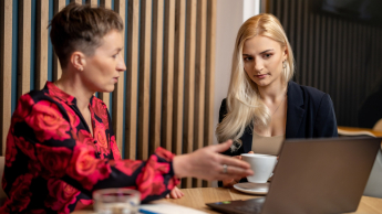 AI: prawo i etyka | Studia podyplomowe w Opolu | Uniwersytet WSB Merito Opole: Główna grafika: Opole - studia podyplomowe - AI: prawo i etyka - uczestniczki studiów podyplomowych siedzą i rozmawiają, analizujać treści z laptopa