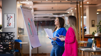 Programista Python Developer | Studia podyplomowe w Opolu | Uniwersytet WSB Merito Opole: Główna grafika: Opole - studia podyplomowe - Programista  Python Developer - uczestniczki studiów podyplomowych analizują wspólnie wykresy z flipcharta