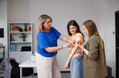 Laboratoria i pracownie | Uniwersytet WSB Merito Opole: Laboratorium dietetyczne, trzy studentki pracują projektowo, jedna z nich ma pomiar ramienia