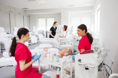 Laboratoria i pracownie | Uniwersytet WSB Merito Opole: Laboratorium kosmetologiczne, dwie studentki przeprowadzają zabieg kosmetologiczny