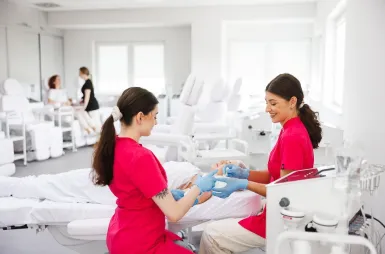 Laboratoria i pracownie | Uniwersytet WSB Merito Opole: Laboratorium kosmetologiczne, dwie studentki przeprowadzają zabieg kosmetologiczny