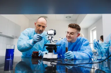 Laboratoria i pracownie | Uniwersytet WSB Merito Opole: laboratorium chemii, dwoje studentów ogląda odczynniki pod mikroskopem