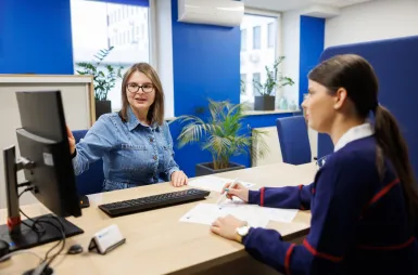 Nasz budynek | Uniwersytet WSB Merito Opole: Dziewczyna załatwiająca sprawy w dziekanacie