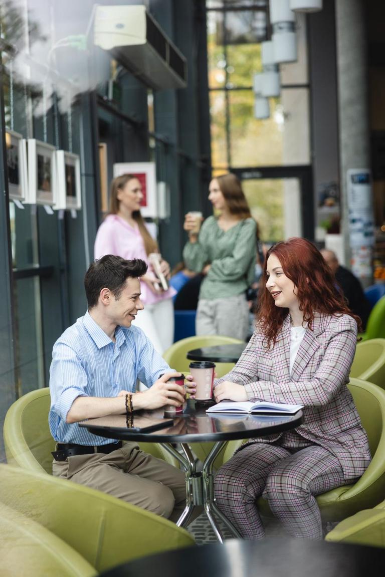 Poznaj nas | Uniwersytet WSB Merito Opole: Studenci Uniwersytetu WSB Merito Opole rozmawiający przy kawie