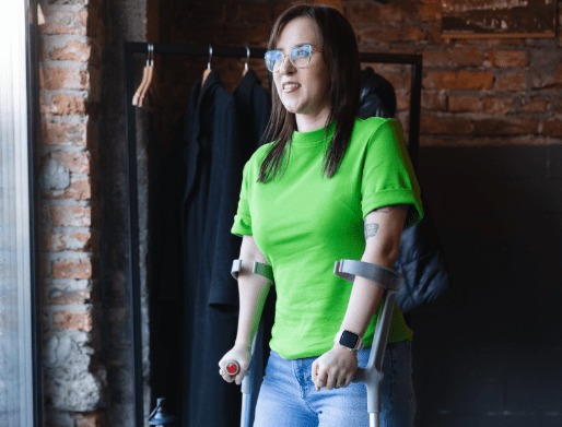 Uczelnia bez barier | Uniwersytet WSB Merito Opole: Niepełnosprawna dziewczyna, stojąca o kulach.