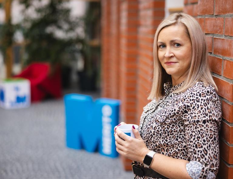 Finanse i rachunkowość | Studia II stopnia w Opolu | Uniwersytet WSB Merito Opole: Kobieta trzymająca kubek z logotypem Merito