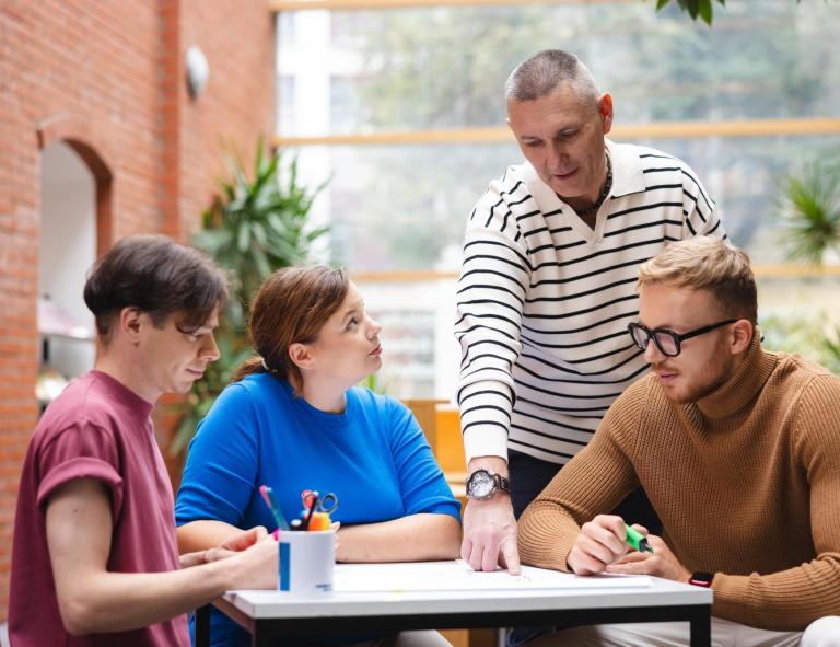 Prawo e-biznesu i sztucznej inteligencji | Studia I stopnia w Opolu | Uniwersytet WSB Merito Opole: Grupa studentów pracująca nad projektem pod okiem wykładowcy