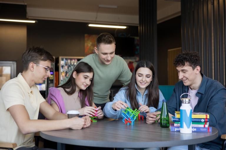 Praca z osobami niedostosowanymi społecznie z profilaktyką uzależnień | Studia I stopnia w Opolu | Uniwersytet WSB Merito Opole: grupa studentów siedząca przy stole 