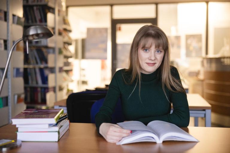 Prawo e-biznesu i sztucznej inteligencji | Studia I stopnia w Opolu | Uniwersytet WSB Merito Opole: Główna grafika: Opole - specjalność mediacje i negocjacje - studentka siedząca przed książką