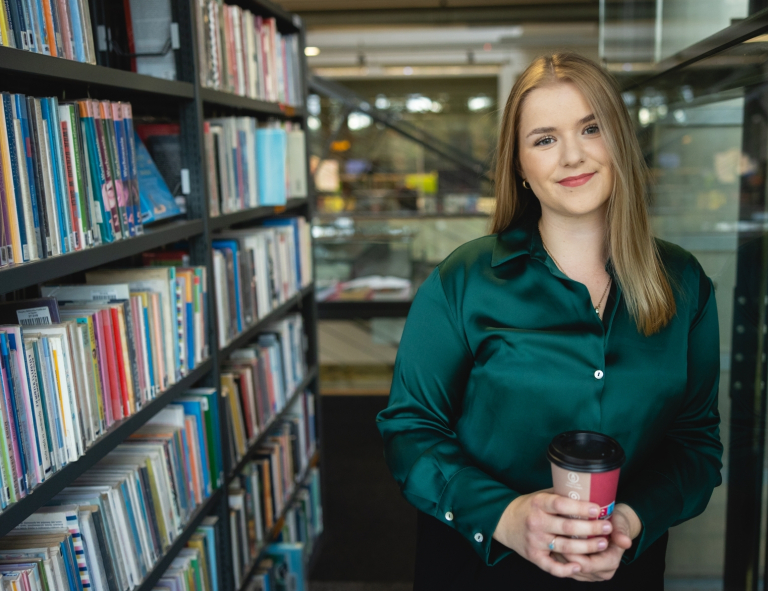 Pedagogika | Studia II stopnia ze studiami podyplomowymi w Opolu | Uniwersytet WSB Merito Opole: Studentka stojąca między regałami w bibliotece