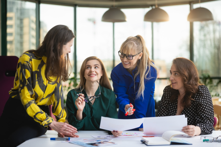 Psychologia kryzysu i interwencji kryzysowej | Studia podyplomowe w Opolu | Uniwersytet WSB Merito Opole: Grupa kobiet pracująca wspólnie nad projektem