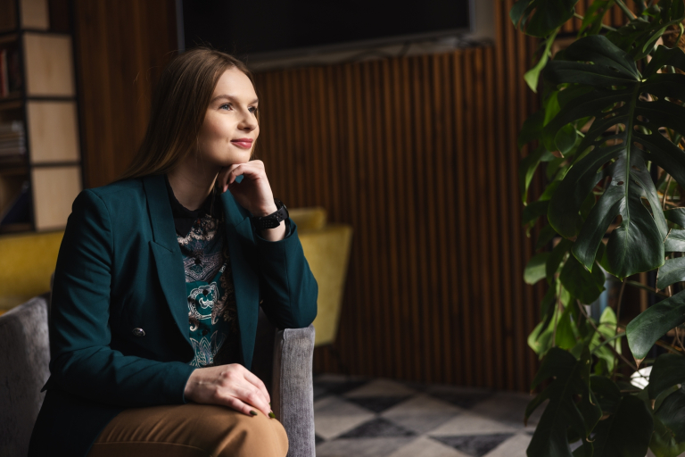 Produkcja muzyczna | Studia podyplomowe w Opolu | Uniwersytet WSB Merito Opole: Kobieta siedząca w fotelu, patrzy w dal