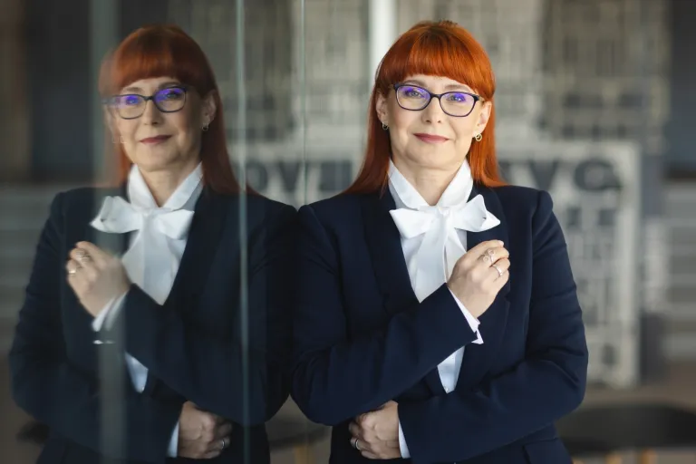 Studia MBA w Opolu | Uniwersytet WSB Merito Opole: Główna grafika: Opole - studia podyplomowe - Psychologia edukacyjna - Kobieta opierająca się o lustro, jest ubrana w granatową marynarkę