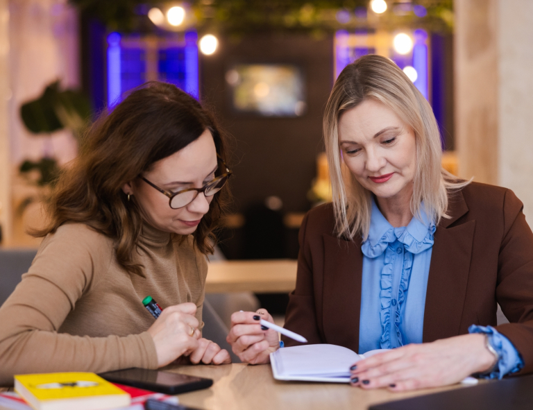 Księgowość i podatki w praktyce | Studia podyplomowe w Opolu | Uniwersytet WSB Merito Opole: Dwie kobiety przeglądające notatki