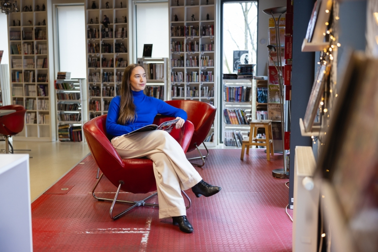 Przygotowanie do wykonywania zawodu nauczyciela psychologa | Studia podyplomowe w Opolu | Uniwersytet WSB Merito Opole: Kobieta siedząca w bibliotece