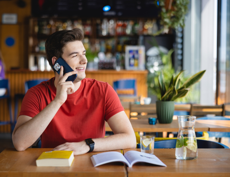 Inżynieria zarządzania | Studia I stopnia w Opolu | Uniwersytet WSB Merito Opole: Mężczyzna siedzący w kawiarni, dzwoni przez telefon