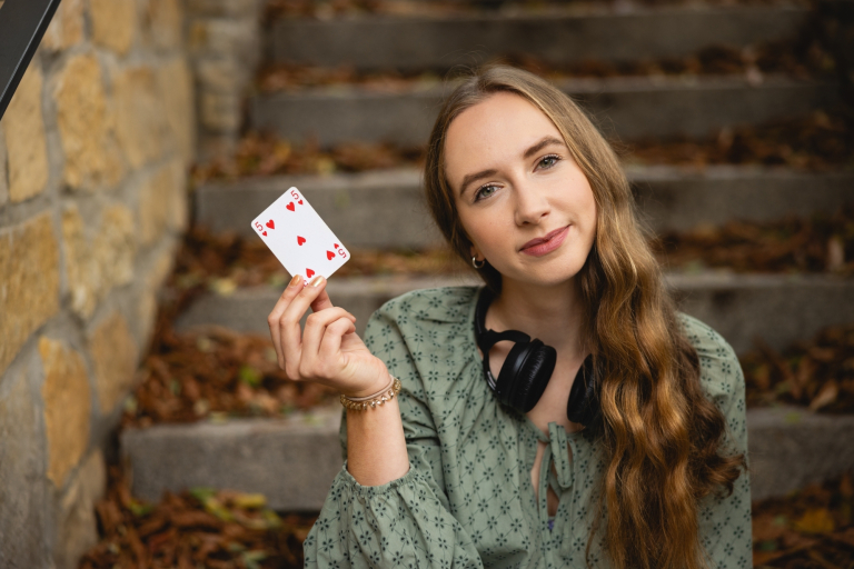 Biznes i nowe technologie | Studia II stopnia ze studiami podyplomowymi  | Uniwersytet WSB Merito Opole: Dziewczyna trzymająca w dłoni kartę do gry