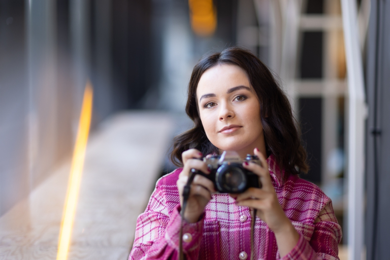 Strona główna | Uniwersytet WSB Merito Opole: Studentka WSB Merito trzyma aparat fotograficzny w ręku