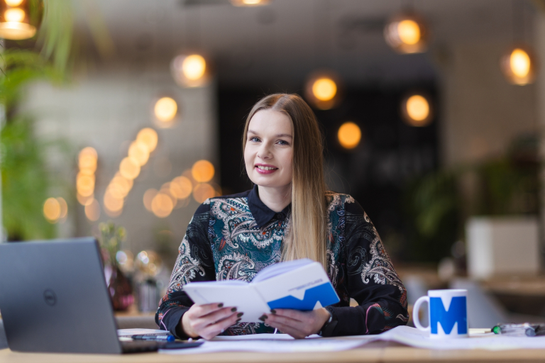 Psychologiczne wsparcie dzieci i młodzieży w kryzysie | Studia podyplomowe w Opolu | Uniwersytet WSB Merito Opole: Kobieta trzymająca w dłoniach notatnik