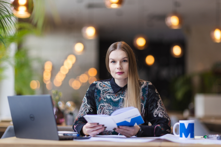 Logistyka w biznesie | Studia podyplomowe w Opolu | Uniwersytet WSB Merito Opole: Kobieta trzymająca w dłoniach notatnik