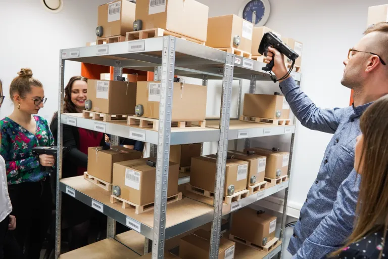 Logistyka | Studia I stopnia w Opolu | Uniwersytet WSB Merito Opole: Laboratorium RFID, grupa studentów pracuje z czytnikiem