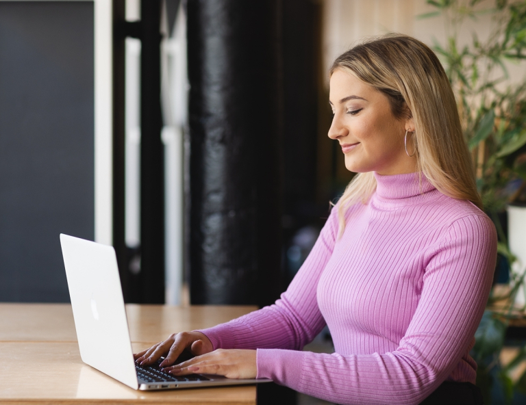 Programowanie | Studia I stopnia w Opolu | Uniwersytet WSB Merito Opole: Studentka siedzi przy biurku z laptopem