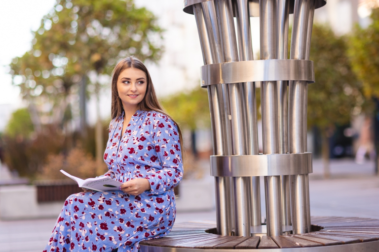 Trychologia z elementami biokosmetologii i fitoterapii | Studia I stopnia w Opolu | Uniwersytet WSB Merito Opole: Studentka siedzi na dworze czytając magazyn