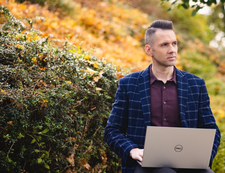 Inżynieria sieci, systemów i bezpieczeństwa IT | Studia I stopnia w Opolu | Uniwersytet WSB Merito Opole: Student siedzi w parku z laptopem