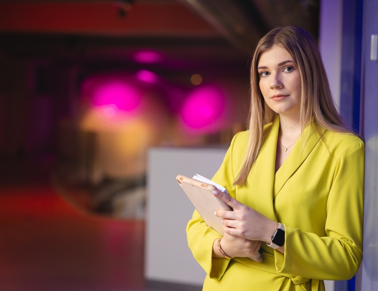 Strategie Digital Marketingu | Studia I stopnia w Opolu | Uniwersytet WSB Merito Opole: Studentka opiera się o ścianę z tabletem w ręce