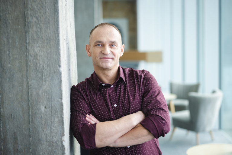 Kompetencje przyszłości - przewaga w świecie zmian | Studia podyplomowe w Opolu | Uniwersytet WSB Merito Opole: Uczestnik studiów podyplomowych opiera się o ścianę z założonymi rękami