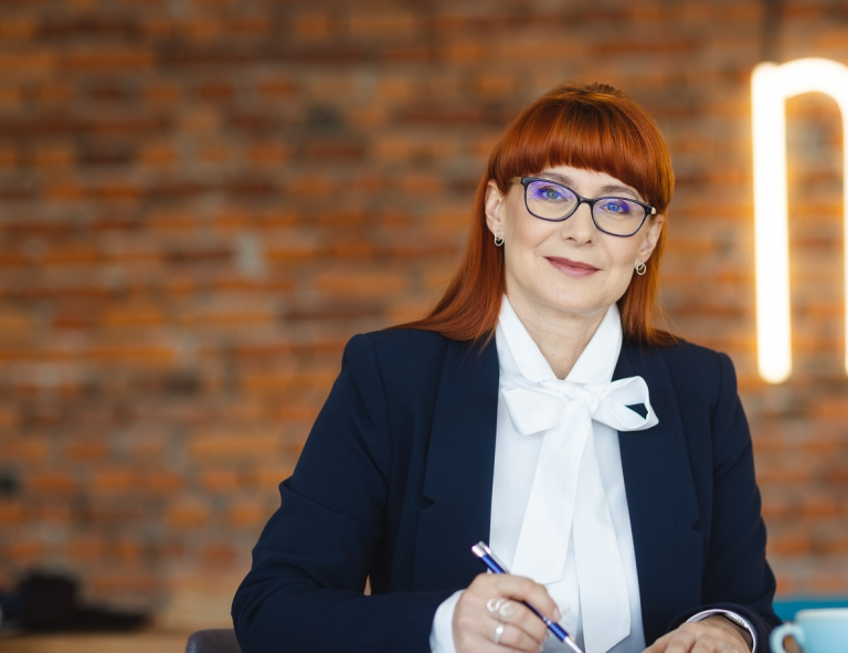 Terapia uzależnień | Studia podyplomowe w Opolu | Uniwersytet WSB Merito Opole: Uczestniczka studiów podyplomowych siedzi i robi notatki