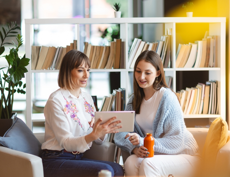 Dietetyka pediatryczna | Studia II stopnia ze studiami podyplomowymi  | Uniwersytet WSB Merito Opole: Uczestniczki studiów podyplomowych siedzą przy biurku i rozmawiają 