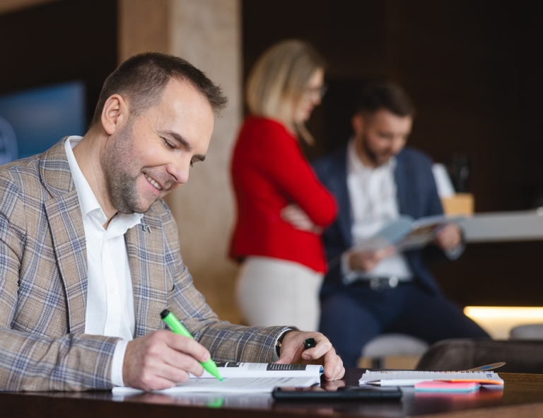 AI: prawo i etyka | Studia podyplomowe w Opolu | Uniwersytet WSB Merito Opole: Uczestnik studiów podyplomowych siedzi i robi notatki