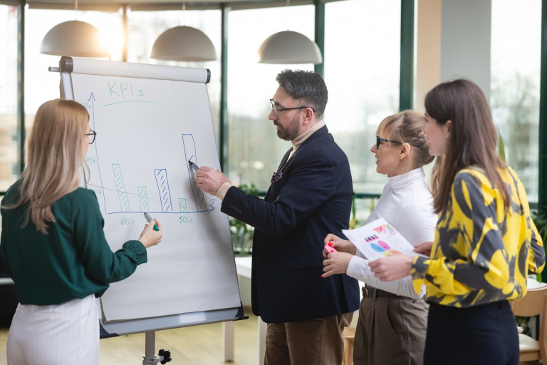 Kadry i płace, studia podyplomowe: Uczestnicy studiów podyplomowych analizują treści na flipcharcie