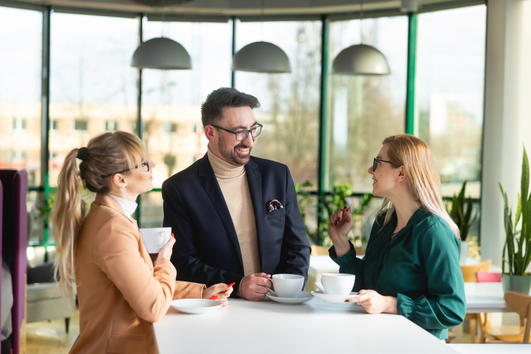 Neurodietetyka, studia podyplomowe: Uczestnicy studiów podyplomowych stoja z filiżankami i rozmawiaja