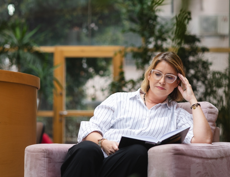 Psychodietetyka i terapia zaburzeń odżywiania | Studia II stopnia ze studiami podyplomowymi  | Uniwersytet WSB Merito Opole: Uczestniczka studiów podyplomowych siedzi i czyta książkę