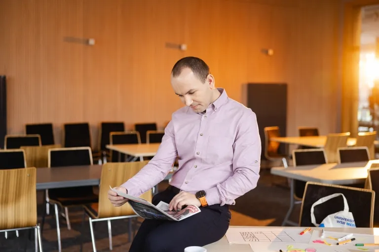 HR menedżer | Studia podyplomowe w Opolu | Uniwersytet WSB Merito Opole: Uczestnik studiów podyplomowych siedzi przy biurku i zagląda w laptopa