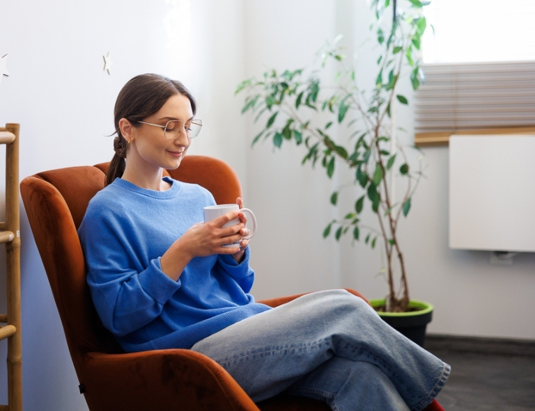 Dietetyka pediatryczna | Studia I stopnia w Opolu | Uniwersytet WSB Merito Opole: Studentka siedzi na fotelu z kubkiem w ręce