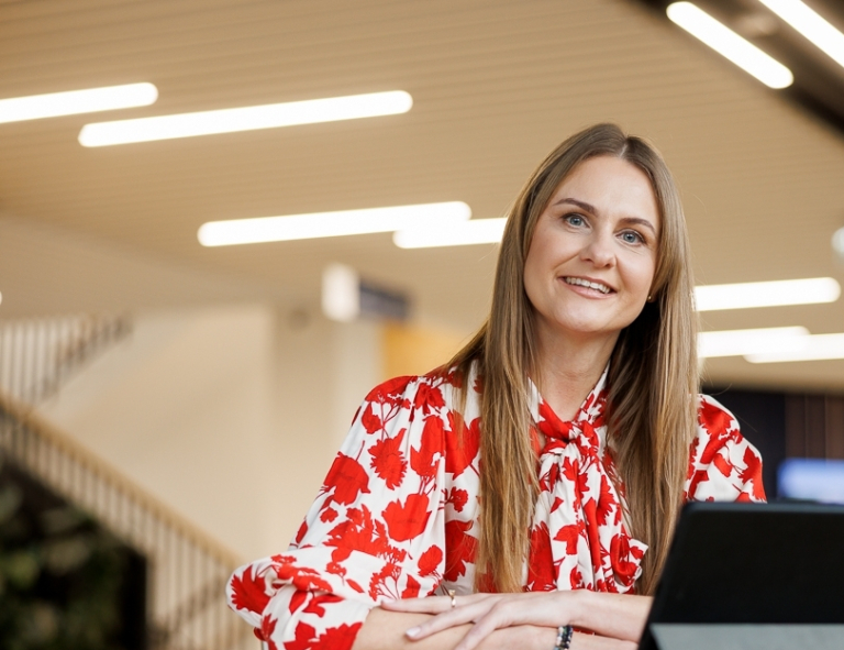 Zarządzanie jakością i produkcją w branży produkcyjnej | Studia podyplomowe w Opolu | Uniwersytet WSB Merito Opole: Uczestniczka studiów podyplomowych siedząca przy biurku z laptopem.