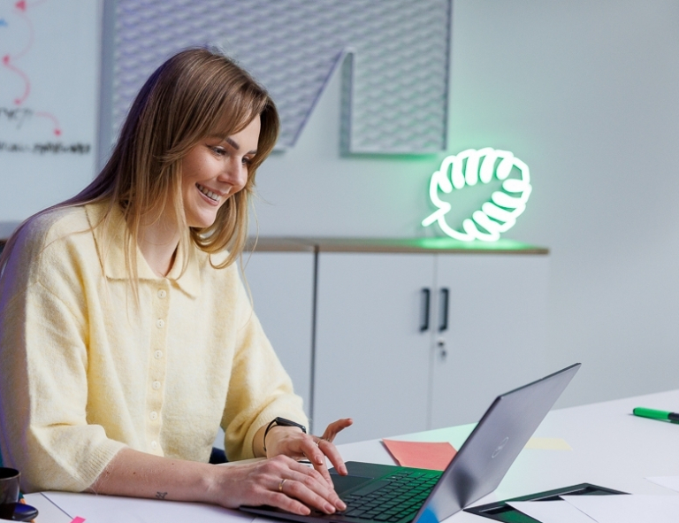 Zastosowanie AI w biznesie dla menedżerów | Studia podyplomowe w Opolu | Uniwersytet WSB Merito Opole: Uczestniczka studiów podyplomowych siedzi przy biurku i pracuje przy laptopie