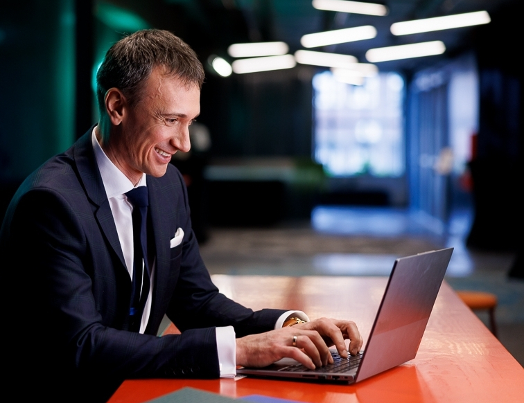 Cross-Border e-Commerce | Studia podyplomowe w Opolu | Uniwersytet WSB Merito Opole: Uczestnik studiów podyplomowych siedzi przy biurku i pracuje na laptopie