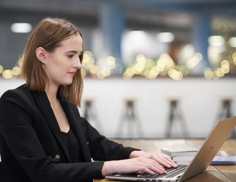 Product Manager w erze AI - zarządzanie produktami cyfrowymi | Studia podyplomowe w Opolu | Uniwersytet WSB Merito Opole: Uczestniczka studiów podyplomowych siedzi przy biurku i pracuje przy laptopie