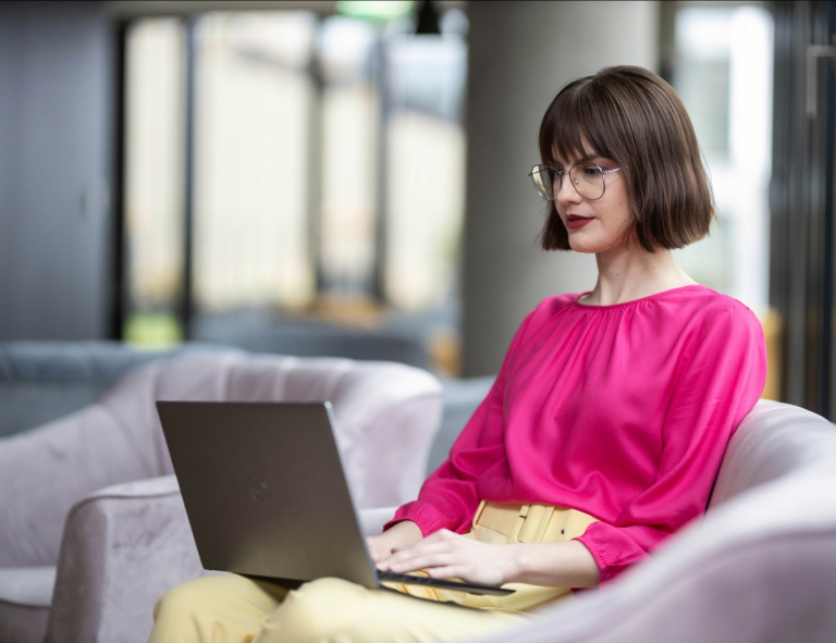 Projektowanie i rozwój nowoczesnych aplikacji SAP FIORI | Studia podyplomowe w Opolu | Uniwersytet WSB Merito Opole: Uczestniczka studiów podyplomowych siedząca przy biurku z laptopem.