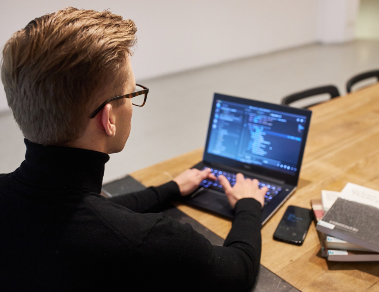 Analiza transakcyjna w organizacjach | Studia podyplomowe w Opolu | Uniwersytet WSB Merito Opole: Uczestnik studiów podyplomowych siedzi przy biurku i pracuje na laptopie