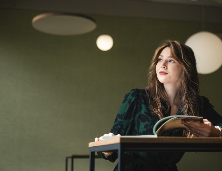 Cyberbezpieczeństwo | Studia I stopnia w Opolu | Uniwersytet WSB Merito Opole: Studentka siedzi przy biurku z książką w ręku