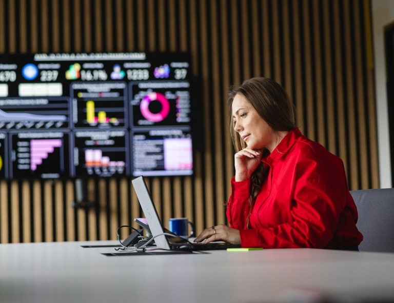 STEAM i sztuczna inteligencja w edukacji | Studia podyplomowe w Opolu | Uniwersytet WSB Merito Opole: Uczestniczka studiów podyplomowych siedząca przy biurku z laptopem.