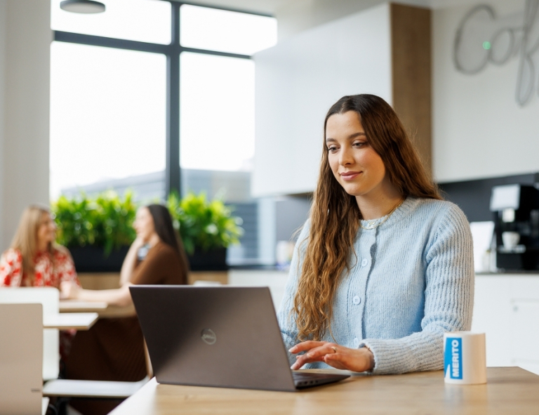 Copywriting sprzedażowy z AI | Studia podyplomowe w Opolu | Uniwersytet WSB Merito Opole: Uczestniczka studiów podyplomowych siedzi i pracuje przy laptopie 
